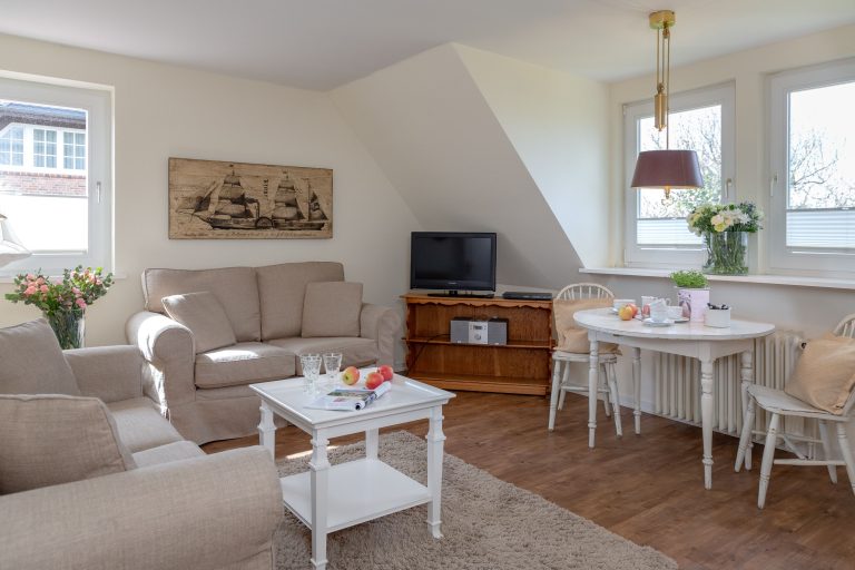 Wohnzimmer mit gedecktem Tisch in einer Ferienwohnung auf Sylt