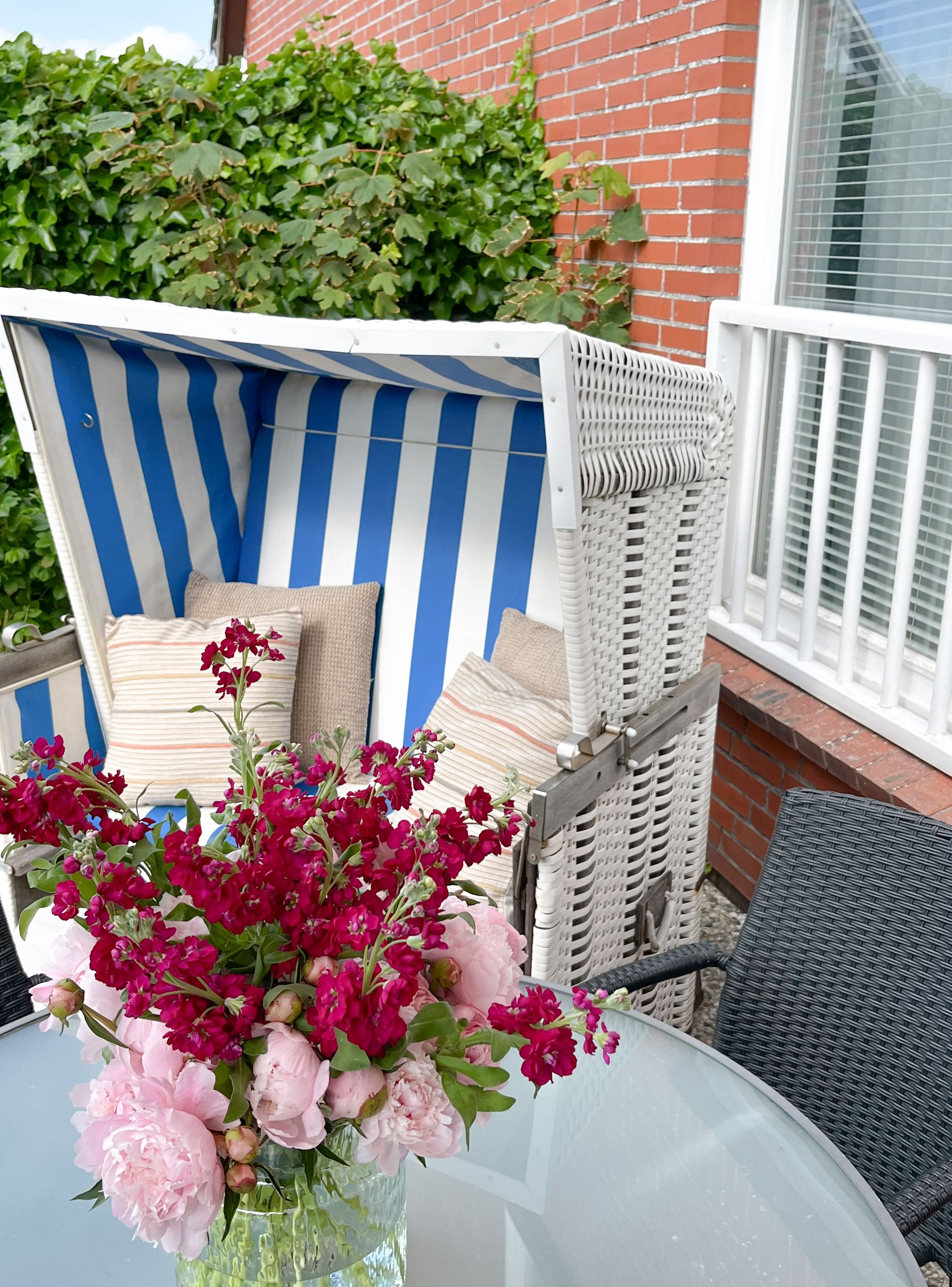 Strandkorb mit Blumen auf einer Terrasse einer Ferienwohnung auf Sylt