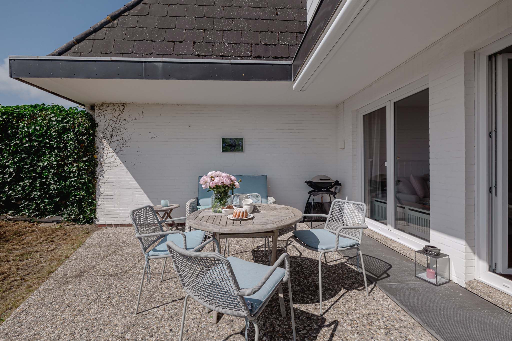 Tisch mit Kuchen und Blumen im Garten einer Ferienwohnung auf Sylt