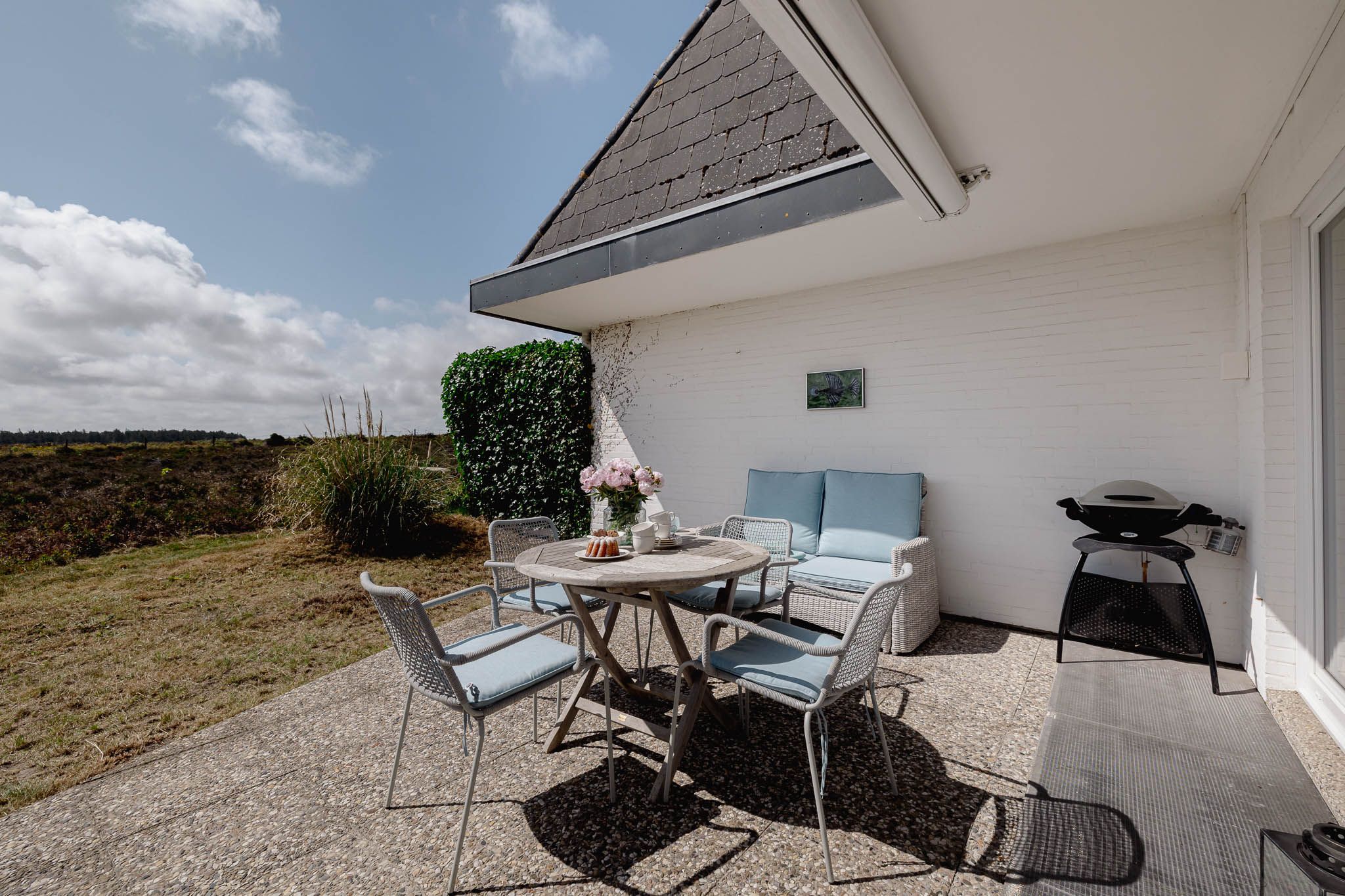 Tisch mit Kuchen und Blumen im Garten einer Ferienwohnung auf Sylt