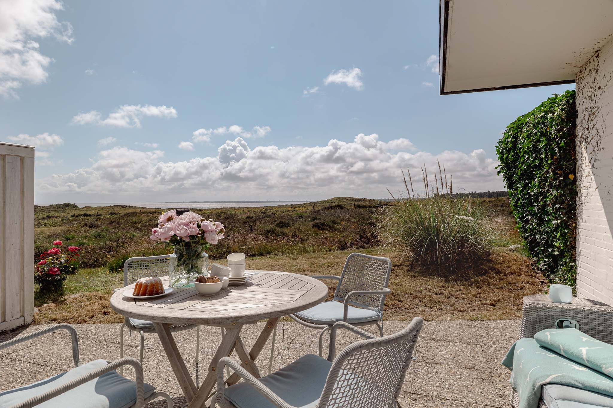 Tisch mit Kuchen und Blumen im Garten einer Ferienwohnung auf Sylt