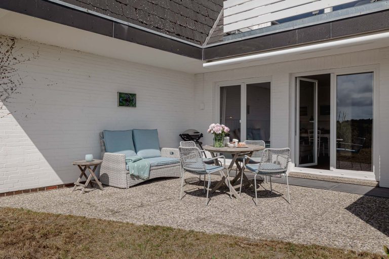 Tisch mit Kuchen und Blumen auf der Terrase einer Ferienwohnung auf Sylt