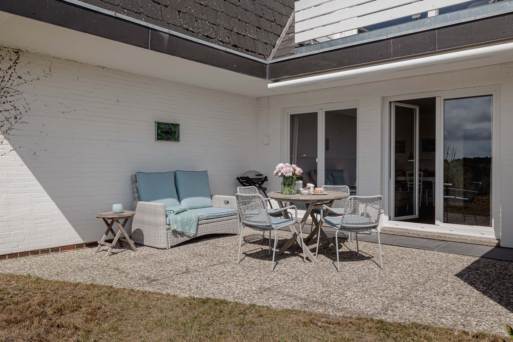 Tisch mit Kuchen und Blumen auf der Terrase einer Ferienwohnung auf Sylt