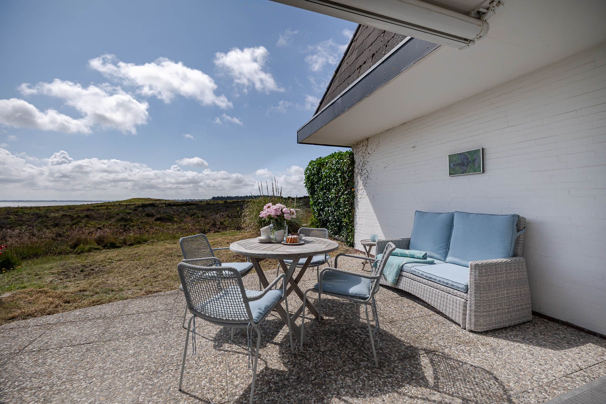 Tisch mit Kuchen und Blumen im Garten einer Ferienwohnung auf Sylt
