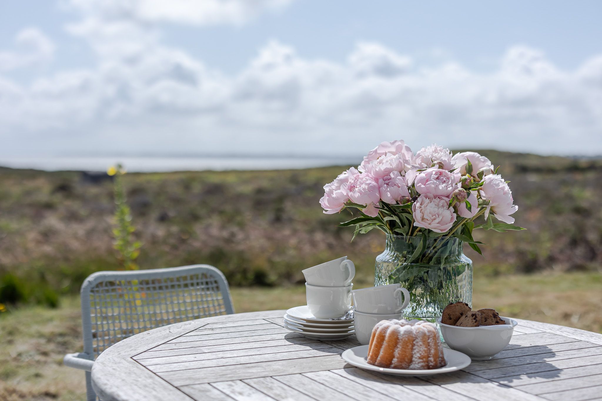 Tisch mit Kuchen und Blumen im Garten einer Ferienwohnung auf Sylt