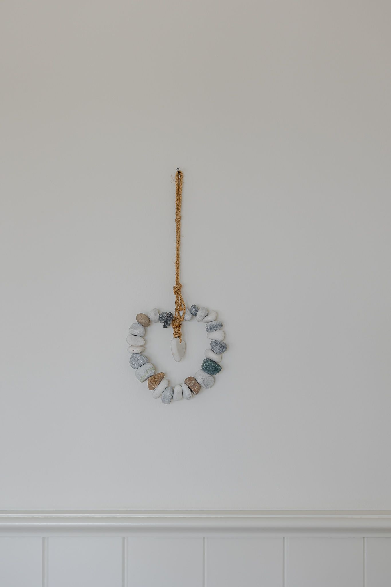 An der Wand hängende Herzdekoration aus Kieselsteinen in einer Ferienwohnung auf Sylt