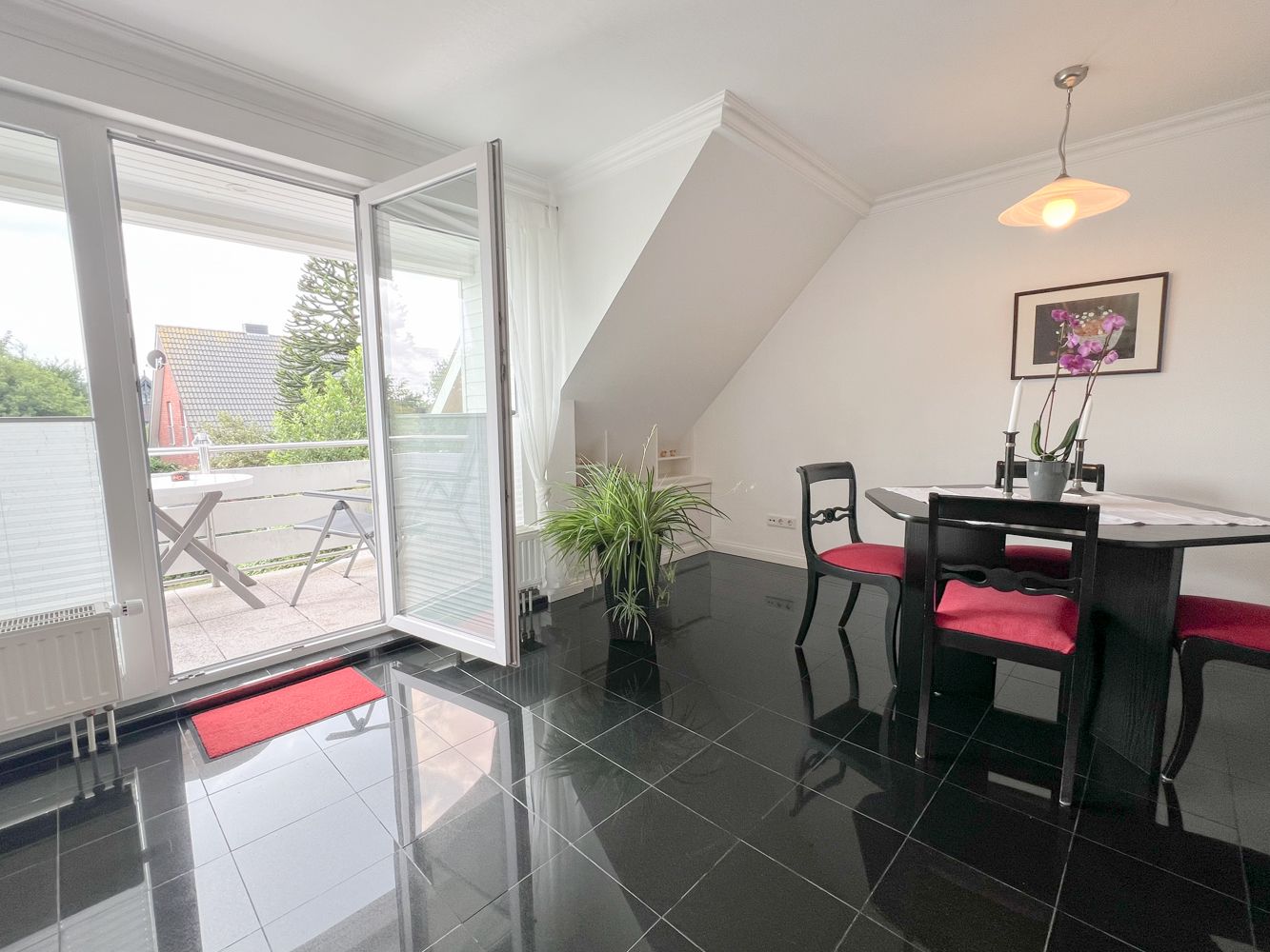 Esstisch und offene Balkontür in einer Ferienwohnung auf Sylt
