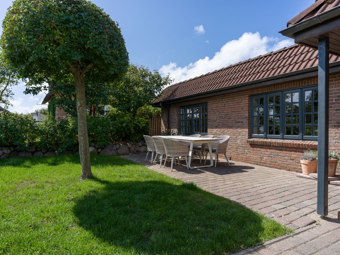 Terrasse, Tisch und Garten einer Ferienwohnung auf Sylt