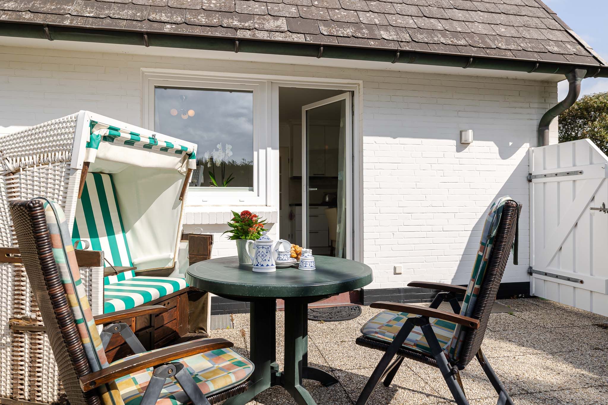 Balkon mit Tisch und Strandkorb in einer Ferienwohnung auf Sylt